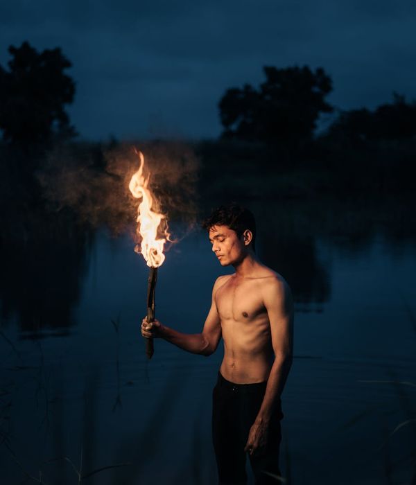 Person in a calm, balanced pose against a serene, dark background with cyan glow.